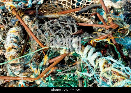 Nahaufnahme des verwickelten Chaos aus rostenden Eisen- und Nylonseilen und Netztuch eines alten Krabbentopfs oder Creels, das an einem Strand angespült wurde. Stockfoto