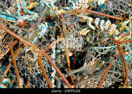 Nahaufnahme des verwickelten Chaos aus rostenden Eisen- und Nylonseilen und Netztuch eines alten Krabbentopfs oder Creels, das an einem Strand angespült wurde. Stockfoto