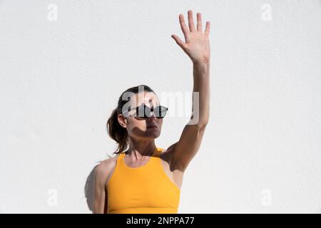 Eine Frau, die ihr Gesicht vor der harten Sonne mit der Hand bedeckte Stockfoto