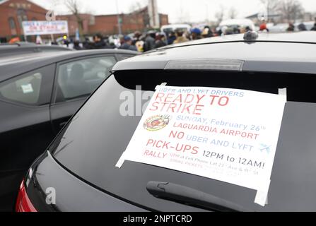 New York, Usa. 26. Februar 2023. Demonstranten halten Schilder hoch, als die New York Taxi Workers Alliance (NYTWA) Uber und Lyft am Sonntag, den 26. Februar 2023 in New York City, auf einem Parkplatz in der Nähe des Flughafens LaGuardia eine Arbeitsunterbrechung abhalten. Der Streik begann mit einer Rallye und Speak-out auf dem LaGuardia Uber/Lyft-Handyplatz, gefolgt von Streikklängen am ganzen Flughafen. Foto: John Angelillo/UPI Credit: UPI/Alamy Live News Stockfoto