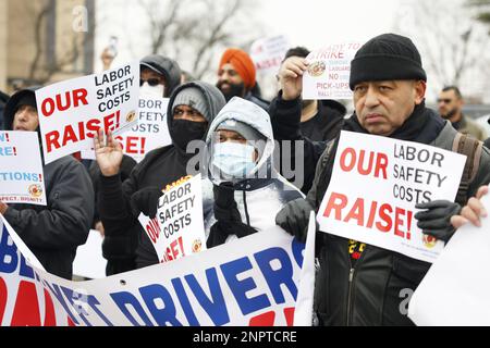 New York, Usa. 26. Februar 2023. Demonstranten halten Schilder hoch, als die New York Taxi Workers Alliance (NYTWA) Uber und Lyft am Sonntag, den 26. Februar 2023 in New York City, auf einem Parkplatz in der Nähe des Flughafens LaGuardia eine Arbeitsunterbrechung abhalten. Der Streik begann mit einer Rallye und Speak-out auf dem LaGuardia Uber/Lyft-Handyplatz, gefolgt von Streikklängen am ganzen Flughafen. Foto: John Angelillo/UPI Credit: UPI/Alamy Live News Stockfoto