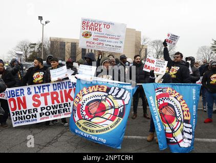 New York, Usa. 26. Februar 2023. Demonstranten halten Schilder hoch, als die New York Taxi Workers Alliance (NYTWA) Uber und Lyft am Sonntag, den 26. Februar 2023 in New York City, auf einem Parkplatz in der Nähe des Flughafens LaGuardia eine Arbeitsunterbrechung abhalten. Der Streik begann mit einer Rallye und Speak-out auf dem LaGuardia Uber/Lyft-Handyplatz, gefolgt von Streikklängen am ganzen Flughafen. Foto: John Angelillo/UPI Credit: UPI/Alamy Live News Stockfoto