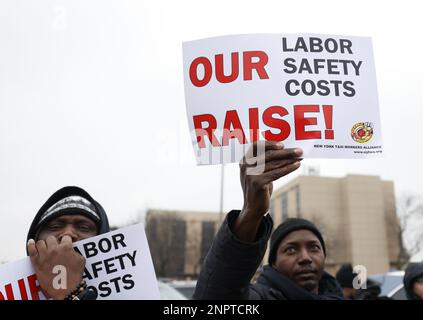 New York, Usa. 26. Februar 2023. Demonstranten halten Schilder hoch, als die New York Taxi Workers Alliance (NYTWA) Uber und Lyft am Sonntag, den 26. Februar 2023 in New York City, auf einem Parkplatz in der Nähe des Flughafens LaGuardia eine Arbeitsunterbrechung abhalten. Der Streik begann mit einer Rallye und Speak-out auf dem LaGuardia Uber/Lyft-Handyplatz, gefolgt von Streikklängen am ganzen Flughafen. Foto: John Angelillo/UPI Credit: UPI/Alamy Live News Stockfoto