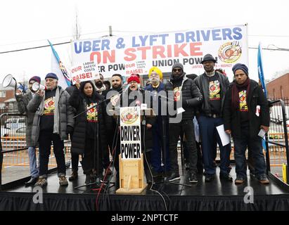 New York, Usa. 26. Februar 2023. Demonstranten halten Schilder hoch, als die New York Taxi Workers Alliance (NYTWA) Uber und Lyft am Sonntag, den 26. Februar 2023 in New York City, auf einem Parkplatz in der Nähe des Flughafens LaGuardia eine Arbeitsunterbrechung abhalten. Der Streik begann mit einer Rallye und Speak-out auf dem LaGuardia Uber/Lyft-Handyplatz, gefolgt von Streikklängen am ganzen Flughafen. Foto: John Angelillo/UPI Credit: UPI/Alamy Live News Stockfoto