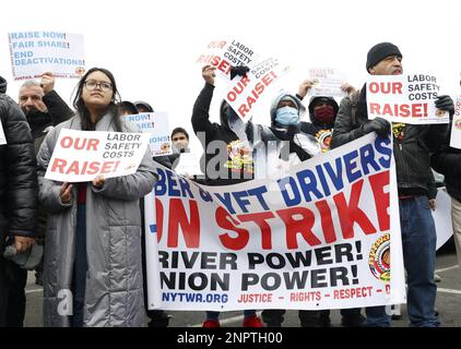 New York, Usa. 26. Februar 2023. Demonstranten halten Schilder hoch, als die New York Taxi Workers Alliance (NYTWA) Uber und Lyft am Sonntag, den 26. Februar 2023 in New York City, auf einem Parkplatz in der Nähe des Flughafens LaGuardia eine Arbeitsunterbrechung abhalten. Der Streik begann mit einer Rallye und Speak-out auf dem LaGuardia Uber/Lyft-Handyplatz, gefolgt von Streikklängen am ganzen Flughafen. Foto: John Angelillo/UPI Credit: UPI/Alamy Live News Stockfoto