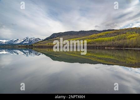 Im Frühling im Norden Kanadas mit schneebedeckten Bergen und Seen an einem ruhigen Tag. Stockfoto