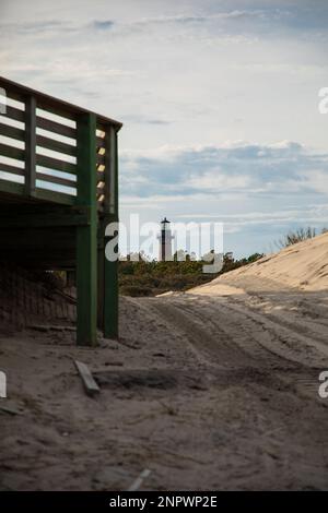 Old Brick Lighthouse mit Blick auf Wald und Dock mit Strand Stockfoto