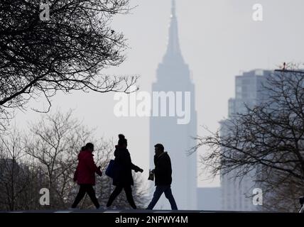 Queens, Usa. 26. Februar 2023. Fußgänger überqueren die 47. Avenue mit Blick auf das Empire State Building im Stadtteil Queens am Sonntag, den 26. Februar 2023 in New York City. Foto: John Angelillo/UPI Credit: UPI/Alamy Live News Stockfoto