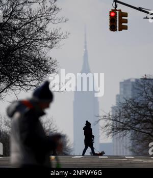 Queens, Usa. 26. Februar 2023. Fußgänger überqueren die 47. Avenue mit Blick auf das Empire State Building im Stadtteil Queens am Sonntag, den 26. Februar 2023 in New York City. Foto: John Angelillo/UPI Credit: UPI/Alamy Live News Stockfoto