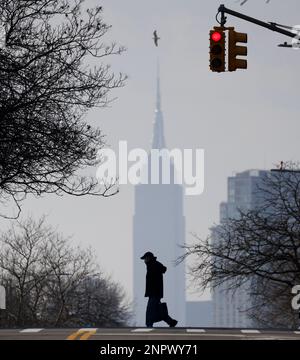 Queens, Usa. 26. Februar 2023. Fußgänger überqueren die 47. Avenue mit Blick auf das Empire State Building im Stadtteil Queens am Sonntag, den 26. Februar 2023 in New York City. Foto: John Angelillo/UPI Credit: UPI/Alamy Live News Stockfoto