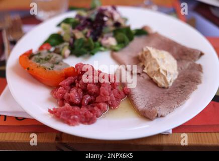 Eine köstliche Vorspeise aus Piedmont. Steak Tartare, Carpaccio, gefüllte Paprika und Salat Stockfoto