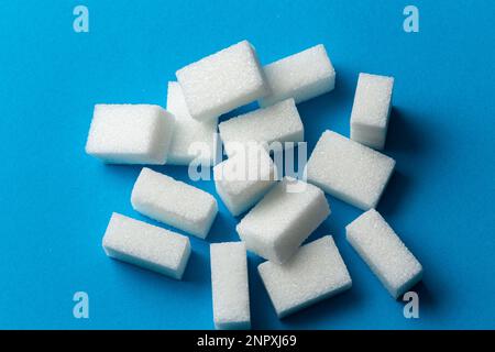 Süß und einfach: Weiße Zuckerwürfel auf blauem Hintergrund Stockfoto
