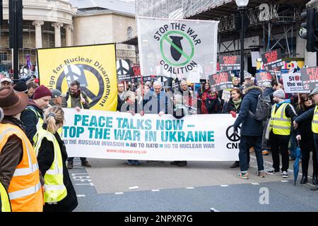 London, Großbritannien. 25. Februar 2023. Demonstranten halten Plakate und Banner, die ihre Meinung während eines demonstrationsmarsches zum Ausdruck bringen. Nach dem ersten Jahrestag des Krieges zwischen Russland und der Ukraine versammelten sich Protestgruppen in Central London und marschierten zum Trafalgar Square, um Frieden in der Ukraine und im Iran zu fordern. Kredit: SOPA Images Limited/Alamy Live News Stockfoto