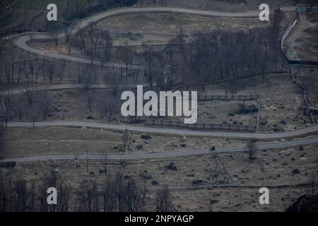 Ein Motorradfahrer fährt an einem wolkigen Wintertag in Astanmarg entlang der Straße, etwa 30kms km von Srinagar, der Sommerhauptstadt von Jammu und Kaschmir entfernt. Stockfoto