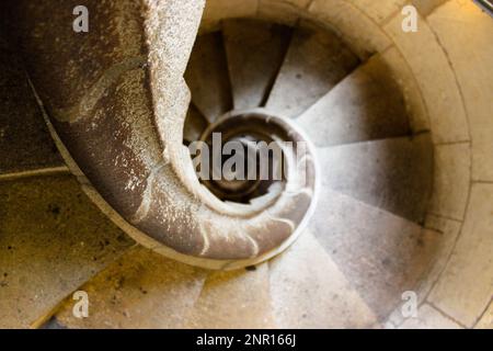 Die Wendeltreppe in einem hellen Stein, von oben gesehen, vermittelt den Eindruck eines Tunnels in Richtung Unendlichkeit. Stockfoto