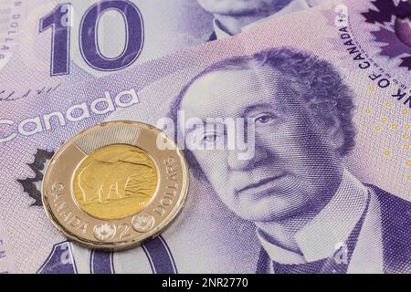 Kanadische zwei-Dollar-Münze auf kanadischen zehn-Dollar-Banknoten mit einem Porträt von Sir John A. Macdonald. Stockfoto