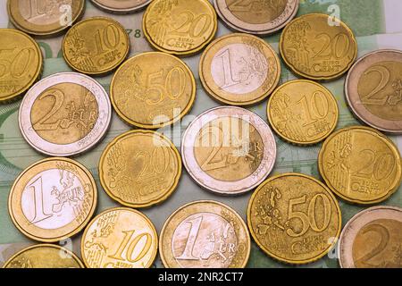 Verschiedene Euro-Münzen auf 100 Euro-Banknoten. Stockfoto