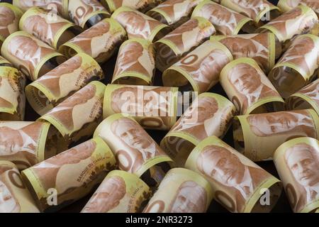 Draufsicht gerollter kanadischer 100-Dollar-Banknoten mit Porträt von Sir Robert L. Borden Forrmer Premierminister von Kanada auf schwarzem Hintergrund. Stockfoto