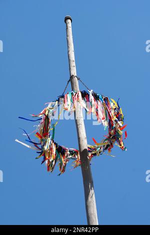 Traditionelle deutsche Maibaum vor blauem Himmel, Mai Feier in Deutschland Stockfoto