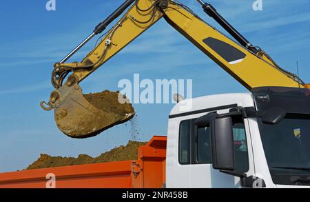 Bagger Balädt LKW. Hydraulikbagger beladen einen Lkw mit Ausschachtung Stockfoto