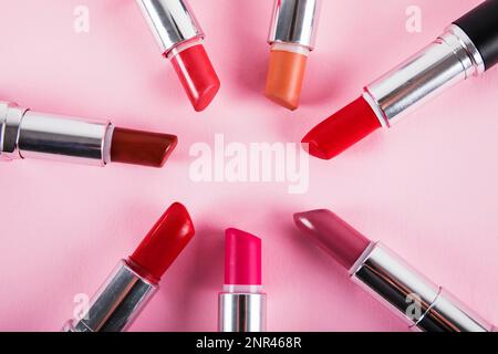 Kollektion verschiedene farbenfrohe Lippenstifte pinkfarbene Oberfläche. Schönes Foto Stockfoto