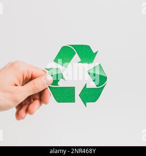 Hand der Person mit grünem Recycling-Symbol weißer Hintergrund. Hochauflösendes Foto Stockfoto