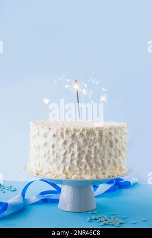 Weißer Geburtstagskuchen mit brennendem Sparkler. Hochauflösendes Foto Stockfoto