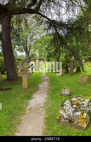 Schotterpfad durch den Friedhof mit alten Grabmarkierungen und Kreuzen bedeckt mit Moos und Flechten in den gotischen Ruinen von Pirita, Tallinn, Estland. Stockfoto