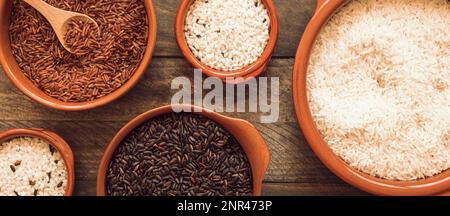 Rot-braune, weiße Reisschüsseln mit Holzhintergrund Stockfoto