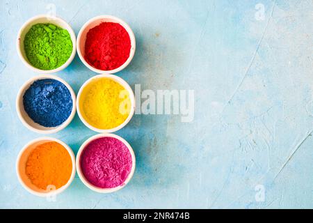 Farbenfrohes puder in weißen Schüsseln mit blauem Hintergrund. Hochauflösendes Foto Stockfoto