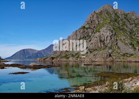 Flache Bucht mit kristallklarem Wasser vor dem Hochgebirge, Henningsvaer, Festvagtind, Gemeinde Vagan, Provinz Nordland, Norwegen Stockfoto