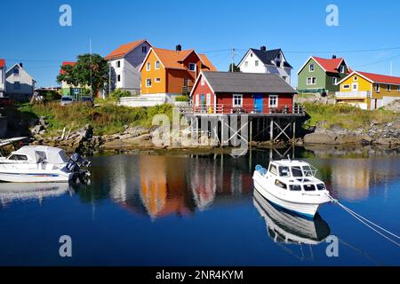 Bunten Häuschen, die sich im kristallklaren Meerwasser widerspiegeln, kleine Freizeitboote und Rorbuer, Henningsvaer, Lofoten, Nordland, Norwegen, Europa Stockfoto