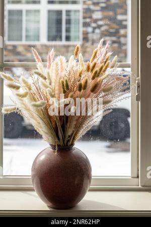 Getrocknetes natürliches Pampasgras in einer Vase am Fenster. Inneneinrichtung. Nahaufnahme. Soft Selective Focus (Weichzeichnermodus) Stockfoto