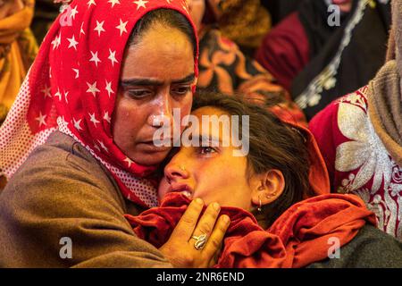 Srinagar, Indien. 25. Februar 2023. Eine muslimische Frau aus Kashmiri tröstet die trauernde Ehefrau von Sanjay Sharma, einem kaschmirischen Hindu-Bankwächter, der von mutmaßlichen Aktivisten in Pulwama südlich von Kaschmir unter indischer Regierung erschossen wurde. Die Polizei sagte, dass mutmaßliche Militanten das Feuer auf Sanjay Sharma eröffneten, während er auf dem Weg zu einem lokalen Markt im Achan-Dorf Pulwama war. (Foto: Faisal Bashir/SOPA Images/Sipa USA) Guthaben: SIPA USA/Alamy Live News Stockfoto