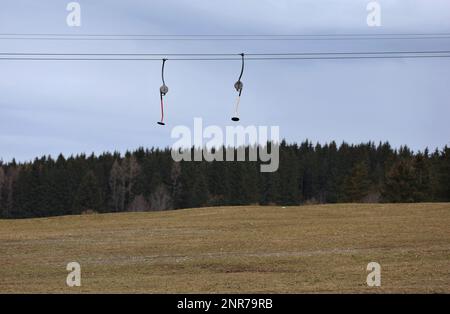 Schwangau, Deutschland. 23. Februar 2023. Die Schilder eines Schlepplifts hängen über der schneelosen Landschaft. Angesichts der oft niedrigen Schneedecke in den Alpen und des fehlenden Regenfalls im Februar, sagen Experten, dass eine massive Dürre bevorsteht. (An dpa: "Erschreckend wenig Schnee: Massive Dürreperioden") Kredit: Karl-Josef Hildenbrand/dpa/Alamy Live News Stockfoto