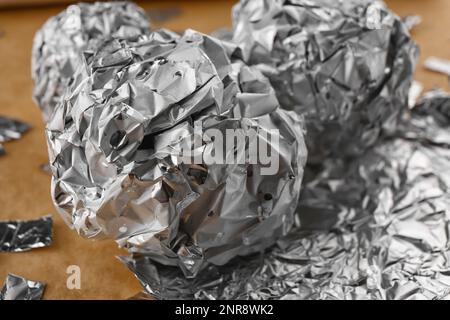 Zerknitterte Kugeln aus Aluminiumfolie auf dem Tisch, Nahaufnahme Stockfoto