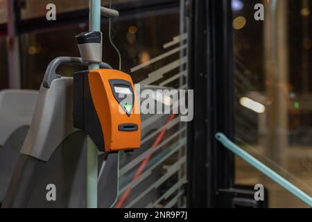 Orangefarbener Ticketprüfer, wie er in öffentlichen Verkehrsmitteln in der Stadt Prag in einer Straßenbahn verwendet wird. Stockfoto