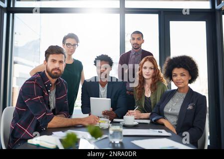 Zusammen sind sie ein starkes Team gleichgesinnter Kreative. Porträt einer Gruppe junger Kreativer, die ein Meeting in einem modernen Büro abhalten. Stockfoto