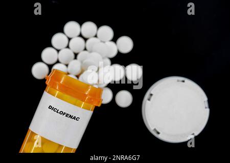 Diclofenac Rx medizinische Pillen in Plazentaflaschen mit Tabletten. Tabletten, die aus dem gelben Behälter austreten. Stockfoto