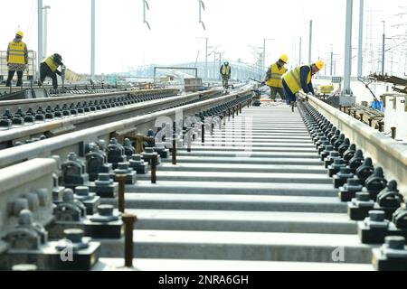 SUZHOU, CHINA - 27. FEBRUAR 2023 - Bauarbeiter arbeiten auf einer ballastlosen Strecke auf der Baustelle der ersten 10 Markierungen des Nyanjiang River Interci Stockfoto