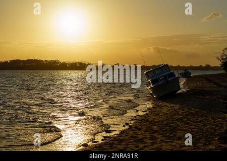 Blick auf den Sonnenuntergang vom Strand von Coochiemudlo Island, Blick über das Wasser nach Victoria Point. Stockfoto