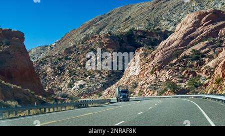 Ein Lastwagen auf dem kurvenreichen Highway zwischen den beiden roten Bergen Stockfoto