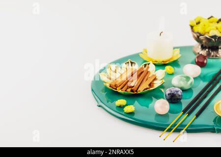 Selbstpflege, heilende Komposition mit Kerzen, Aromastifte, Chakrasteine, Sandelholzstangen und trockenen Blumen auf grünem Marmorpodium. Konzept der Entspannung Stockfoto
