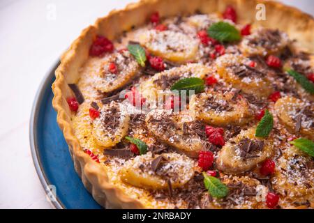 Bananen-Joghurt-Schwammkuchen mit frischen Früchten und Schokolade Stockfoto