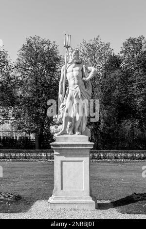 MÜNCHEN, 20. April 2015: Neptun-Statue im Barockgarten und Rückansicht des Schlosses Nymphenburg. München, Bayern, Deutschland Stockfoto