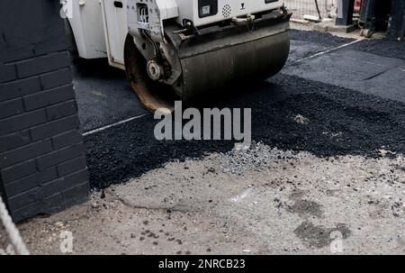 Asphaltverlegemaschine. Asphalt-Eislaufbahn fährt auf einem neuen Straßenbett Stockfoto