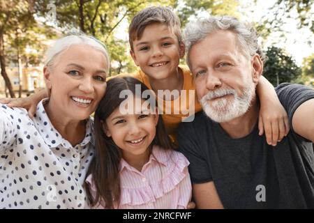 Glückliche Großeltern mit kleinen Kindern, die Selfie im Park machen Stockfoto