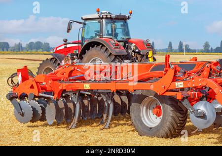 Leistungsstarke mehrreihige Scheibenegge im Hintergrund des landwirtschaftlichen Ackers. Stockfoto