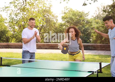 Freunde spielen im Freien Tischtennis am Sommertag Stockfoto