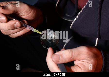 Suchtmensch, der die Spritze mit Drogen füllt, Nahaufnahme Stockfoto